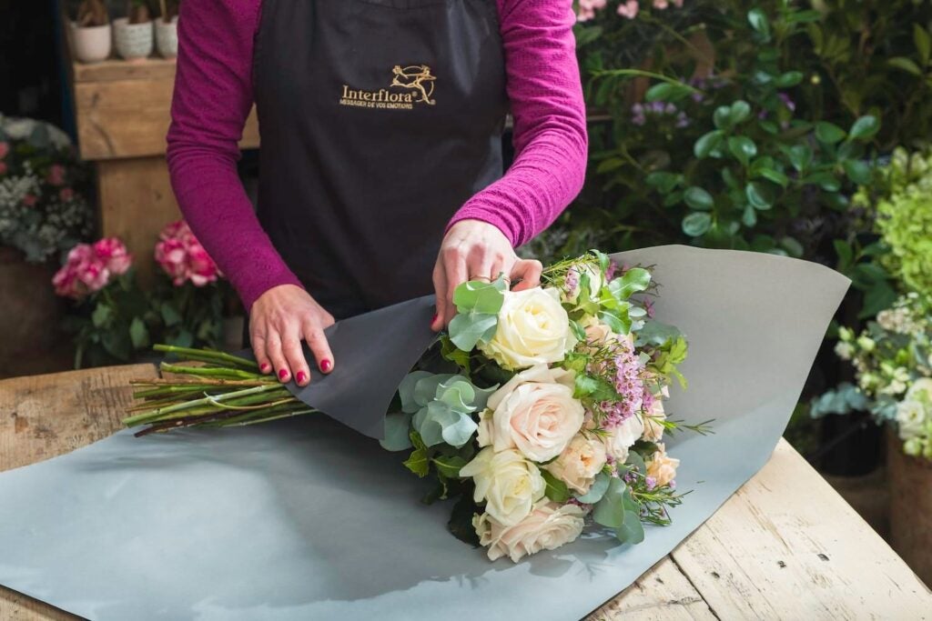 En blomsterhandler gør en buket klar til levering