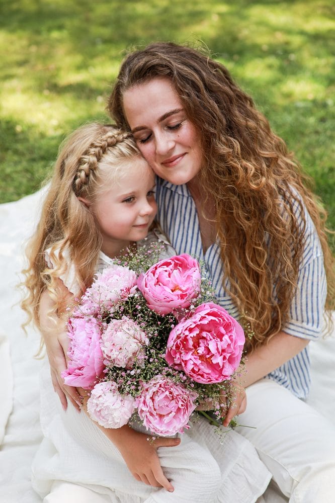mor og datter med pink buket store pæoner i hånden