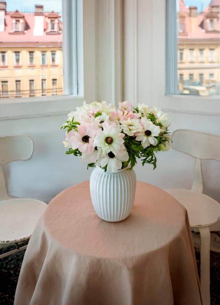 anemonebuket i lyse nuancer på bord med dug