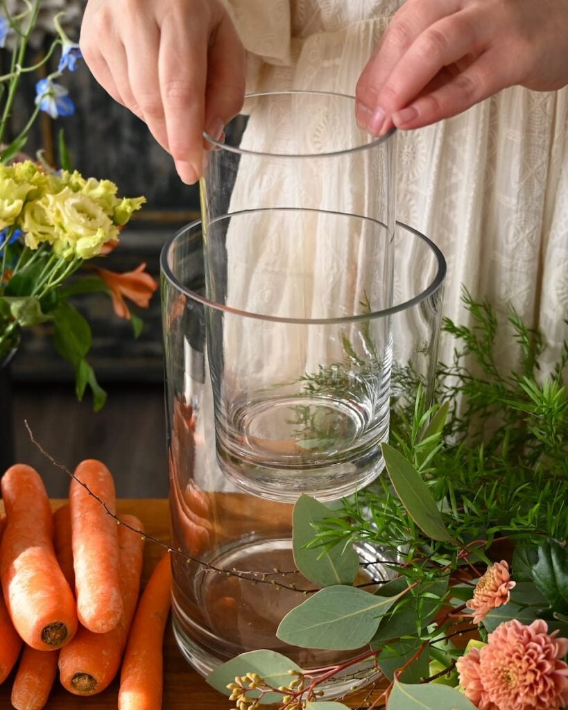 person laver påskeblomsterdekoration med gulerødder