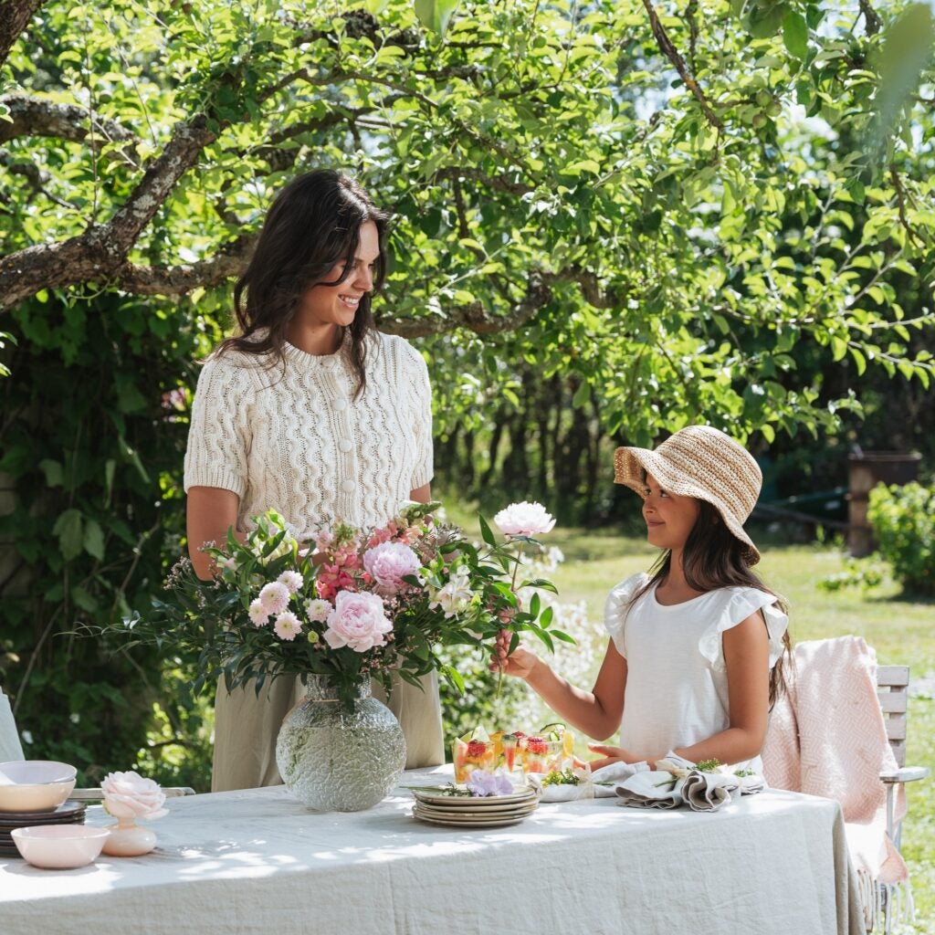 Mor og datter i haven med blomster