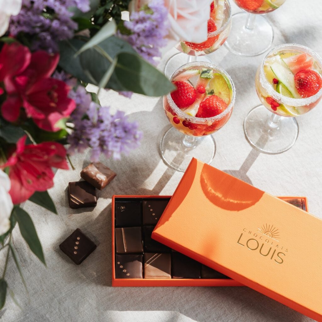 Blomsterbuket, drinks og chokolade på bord