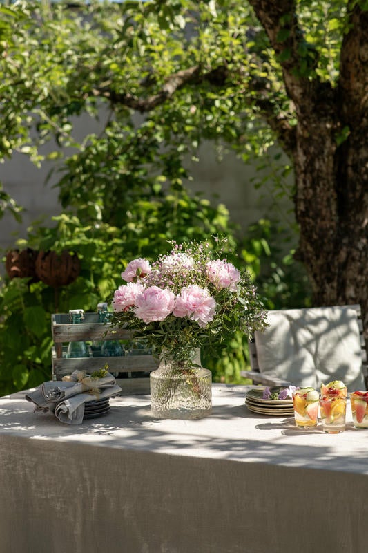 Lyserød pæonbuket på havebord