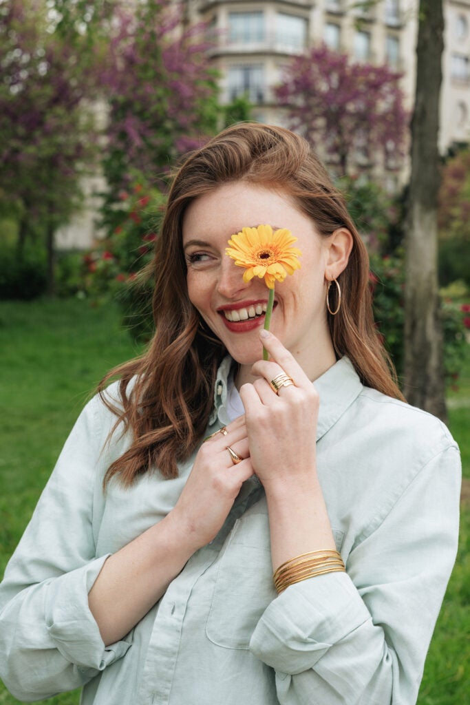 smilende kvinder holder gul gerbera