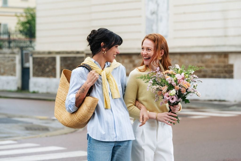 Smilende veninder med en smuk venskabsbuket fra Interflora