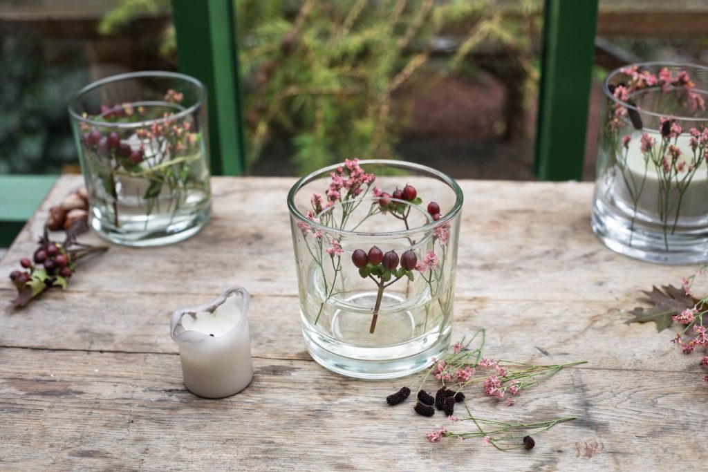 Blomstrende efterårslanterne med perikon, limonium, blodtop og vedbend