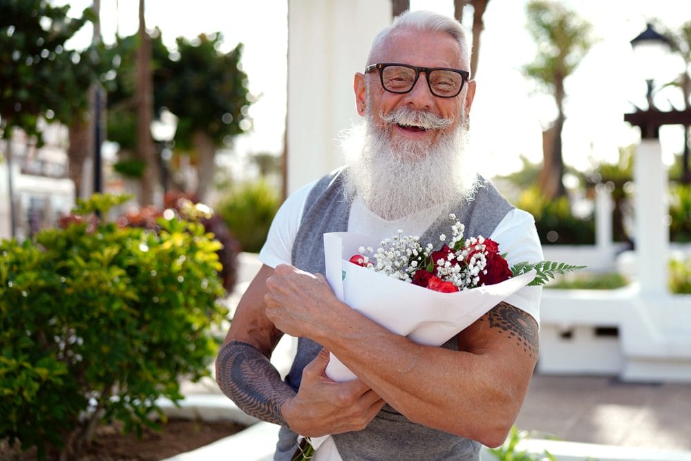 en 60-årig mand med en stor buket blomster i hånden