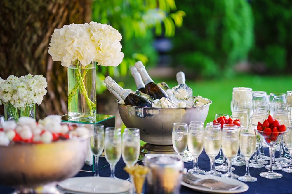 Flaske og glas med champagne på et udendørs bord
