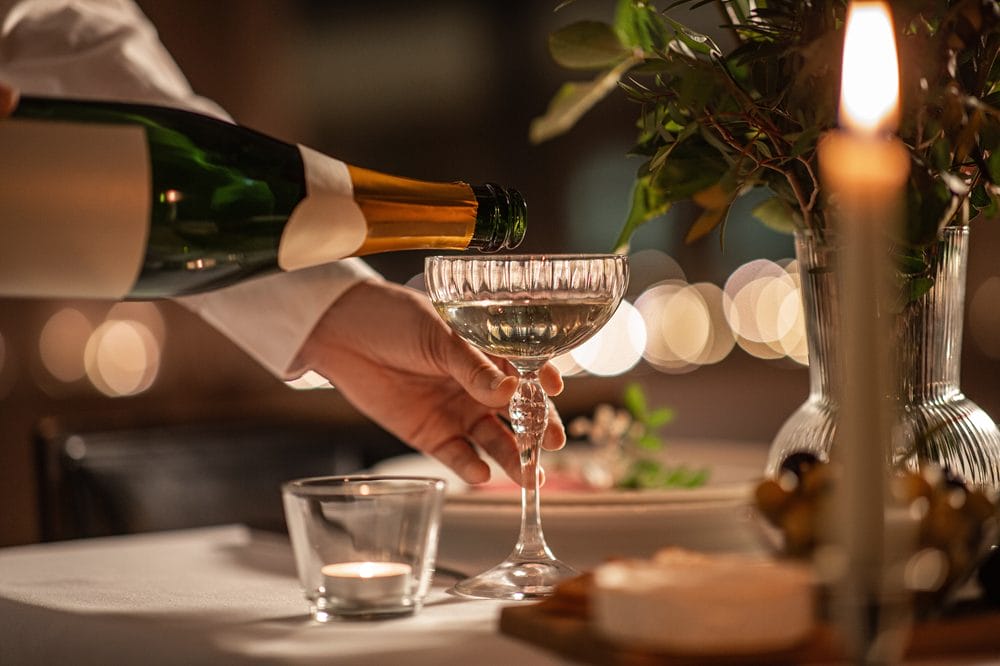 en person serverer champagne i et glas
