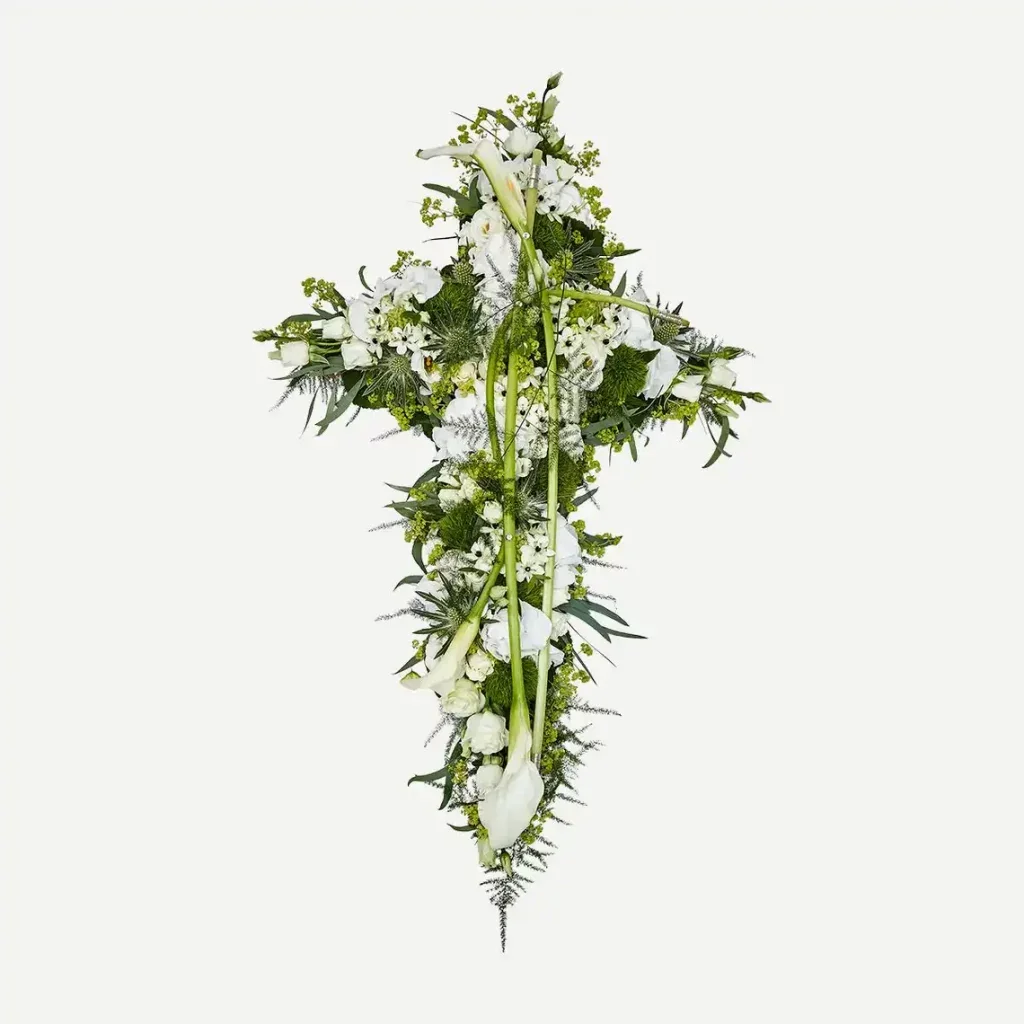 kors begravelsesdekoration med hvide blomster