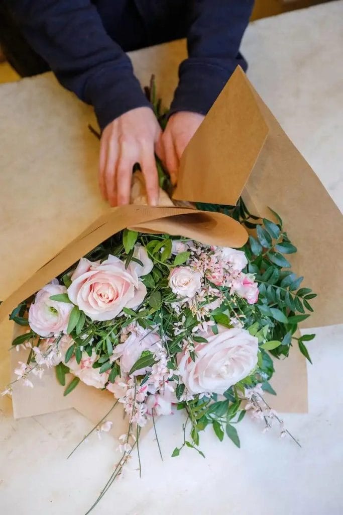 En blomsterhandler pakker en buket ind