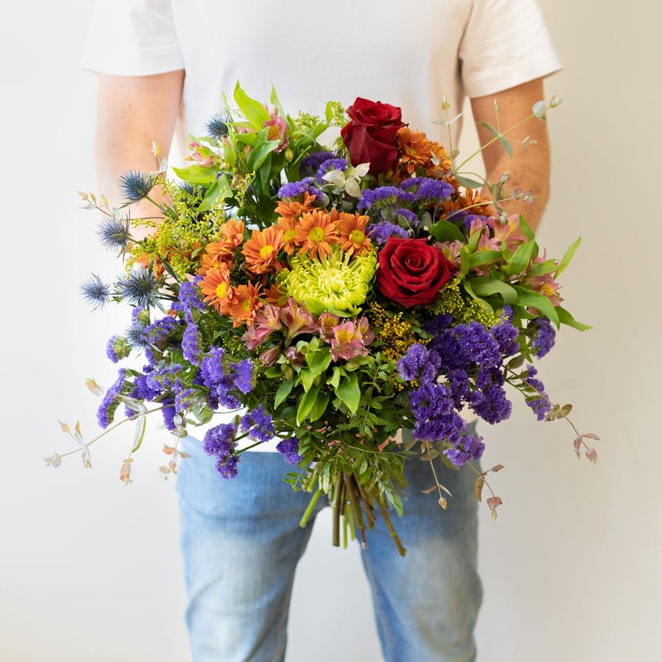 mand holder stor multifarvet blomsterbuket