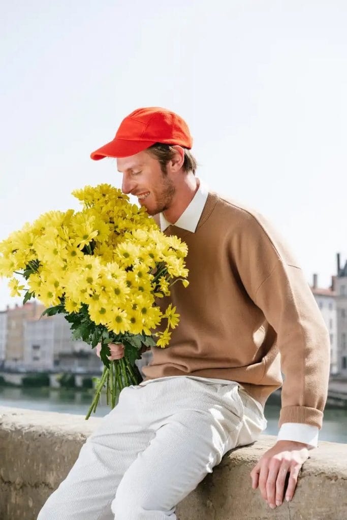 ung mand med en buket gule blomster
