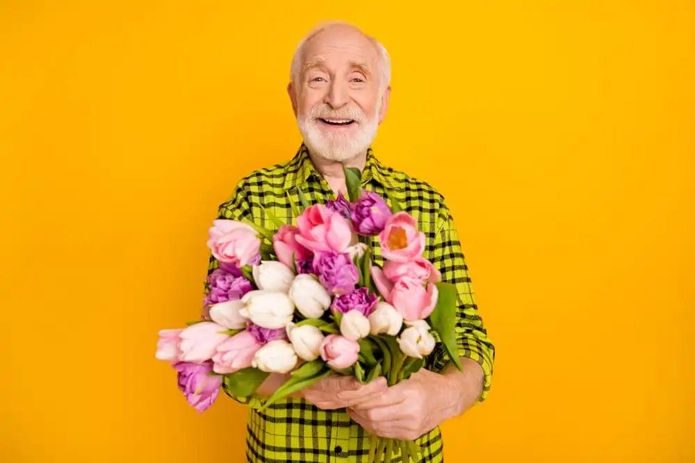ældre mand med en buket blomster i hånden