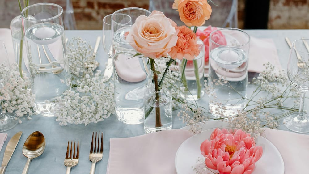 bryllupsbord med orange og lyserøde blomster