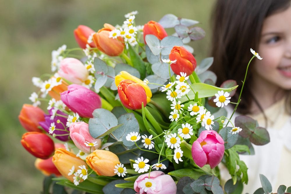 pige holder buket med multifarvede tulipaner