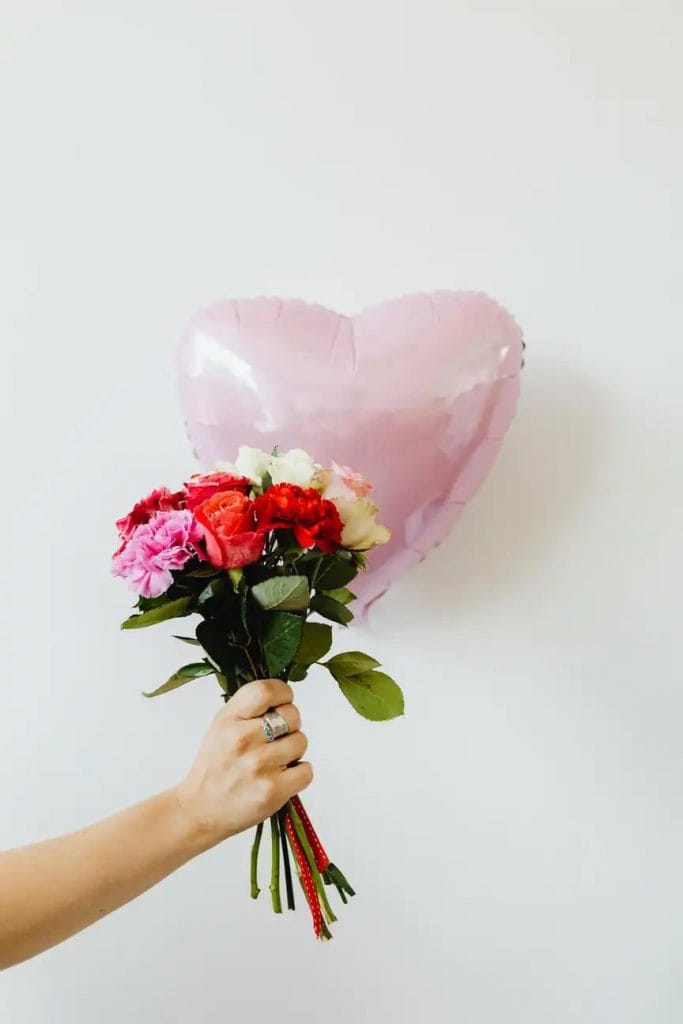 en buket roser foran en hjerteballon