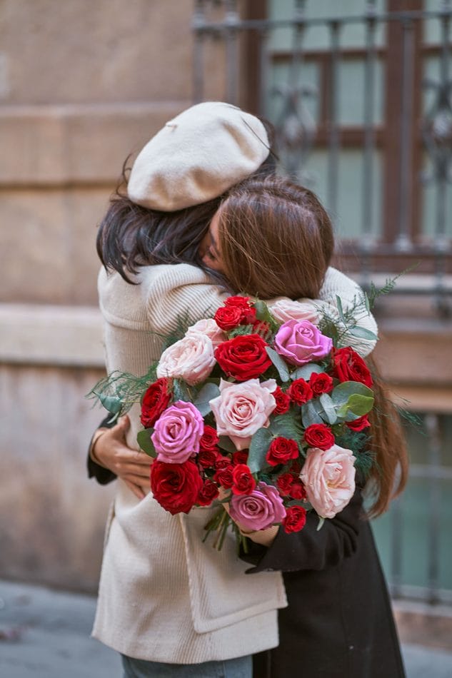 Valentinsdag veninder krammer med rosenbuket